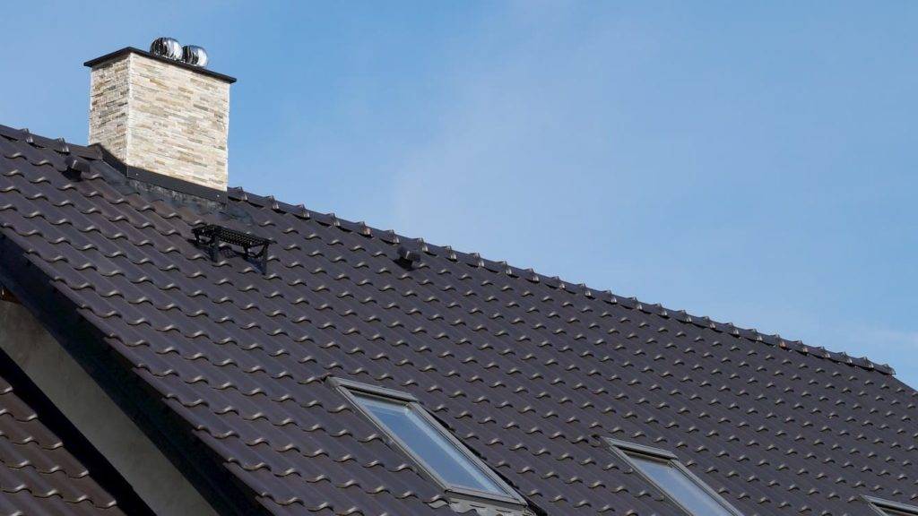 Dark pitched roofing with chimney and velux windows